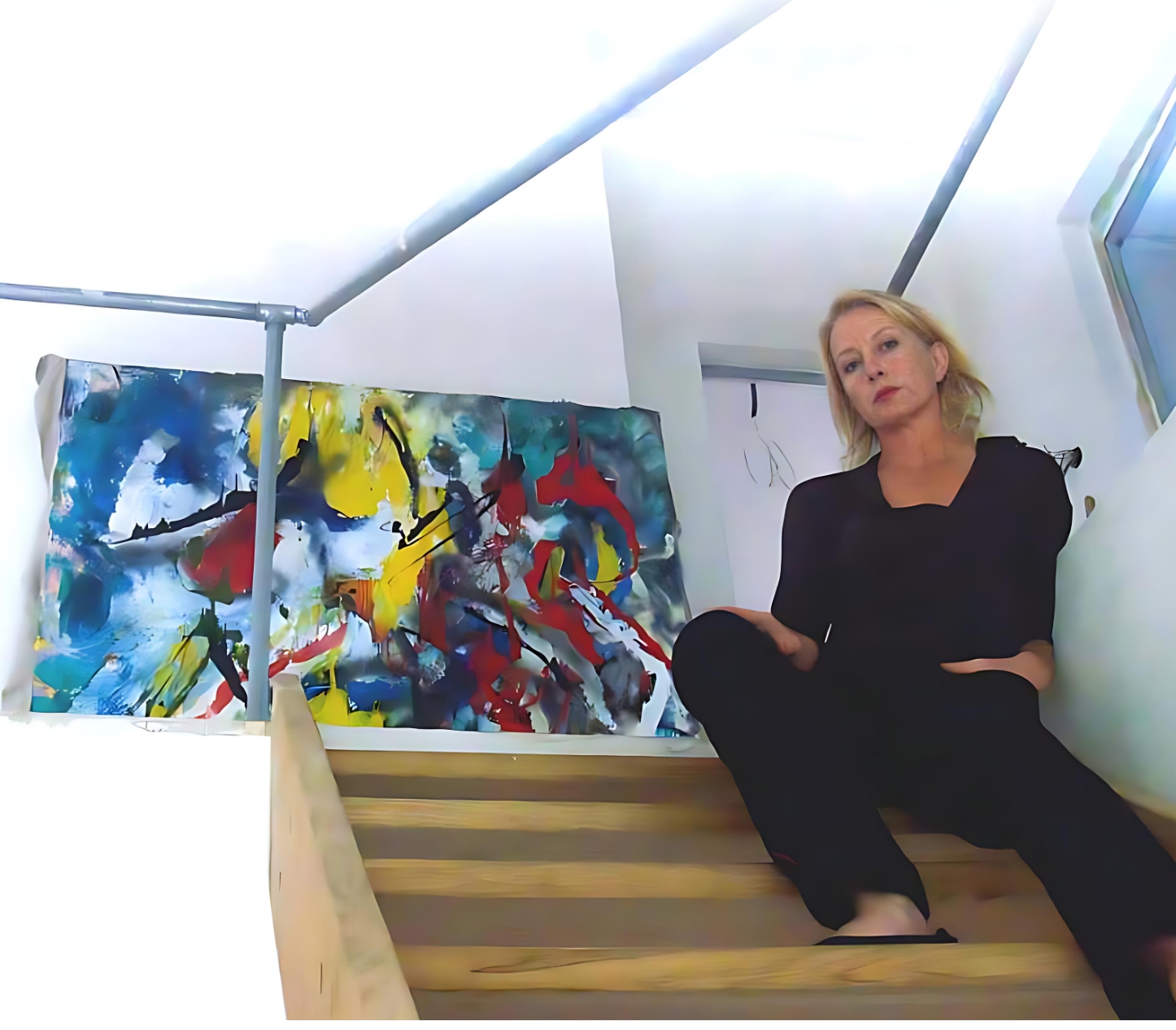 Barbara sitting on the stairs with a painting behind her