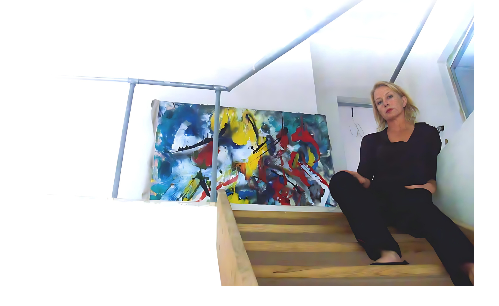 Barbara sitting on the stairs with a painting behind her
